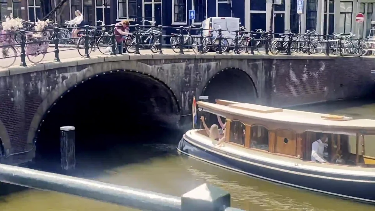 A canal boat passing under an Amsterdam bridge during a previous Teleport experience