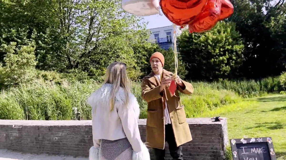 A participant meets a character holding a red umbrella in a garden during an earlier Teleport story